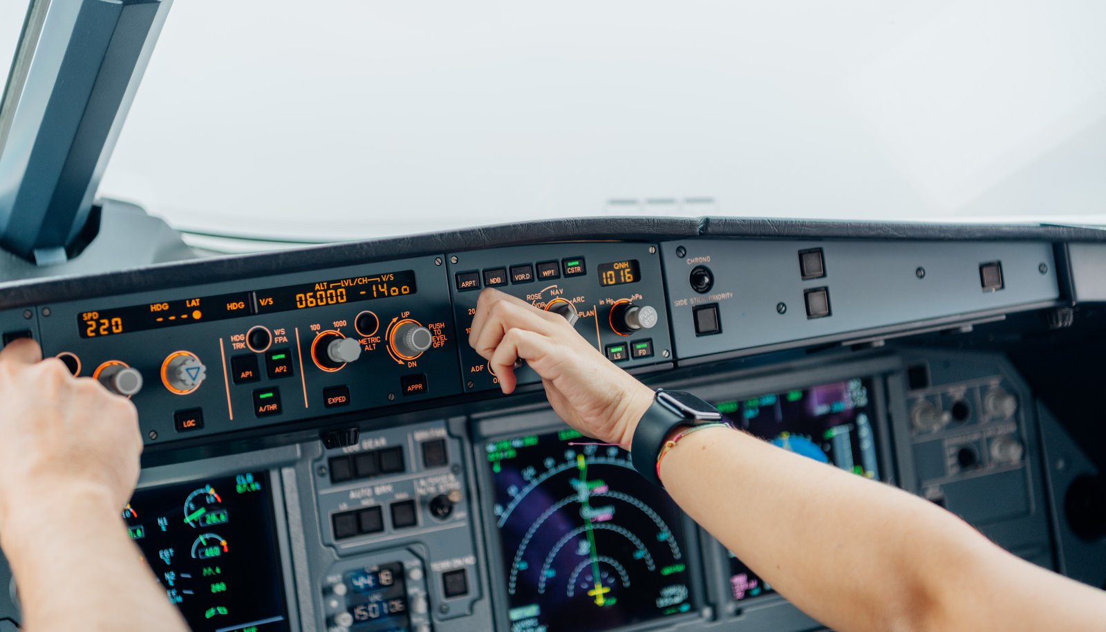 A pilot's hands adjusting the autopilot controls in an aircraft cockpit, representing AI assisting while a human stays in command