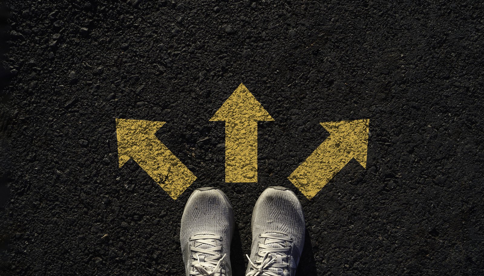 Three yellow directional arrows pointing left, straight, and right on dark pavement, representing three Marketo support options